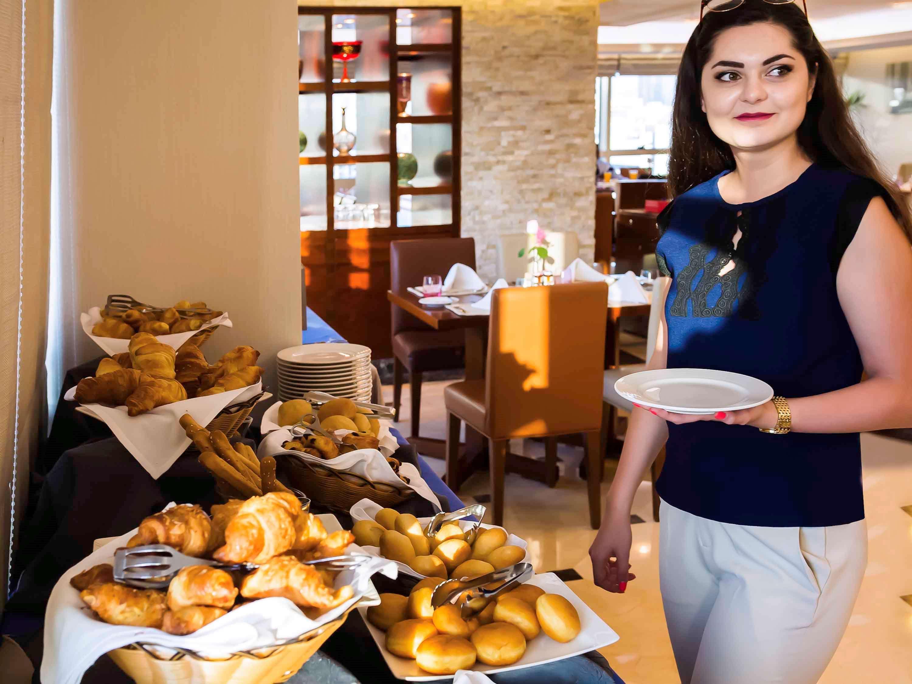 Grand Mercure Majlis Residences Abu Zabi Zewnętrze zdjęcie A hotel staff serving food